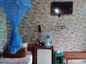 a room with a tv and a couch and a table at Secret View Homestay Ella in Ella