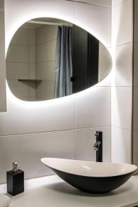 ein Bad mit einem Waschbecken und einem Spiegel in der Unterkunft Le 39-GregIMMO-Appart'Hôtel 