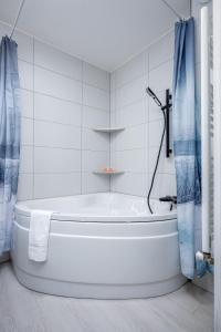 ein weißes Bad mit einer Badewanne und einer Dusche in der Unterkunft Le 39-GregIMMO-Appart'Hôtel 