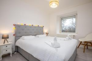 ein Schlafzimmer mit einem großen weißen Bett und einem Fenster in der Unterkunft Le 39-GregIMMO-Appart'Hôtel 