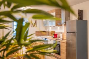 a kitchen with a stainless steel refrigerator and wooden counters at Le 39-GregIMMO-Appart'Hôtel 