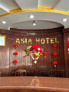 a asia hotel sign on a wooden wall with flowers at Asia Hotel Can Tho in Can Tho