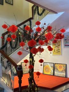 a vase filled with red flowers sitting on a table at Asia Hotel Can Tho in Can Tho