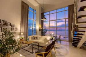 - un salon avec un canapé blanc et une grande fenêtre dans l'établissement Maritime Suites Holiday Rental, à George Town