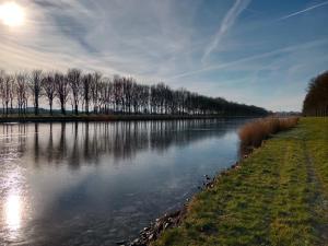 a river with trees on the side of it at La Salicorne, maison d'hôtes. in Brévands