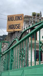 un cartel en una casa con una valla verde en Ardjon House en Berat