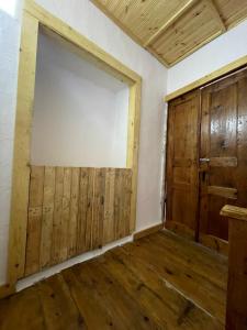 Habitación vacía con puerta grande y suelo de madera. en Ardjon House en Berat