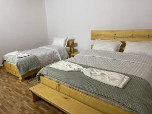 1 dormitorio con 2 camas y un banco entre ellas en Ardjon House en Berat