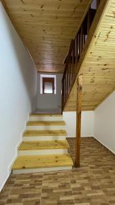 a staircase in a house with wooden ceilings at Ardjon House in Berat