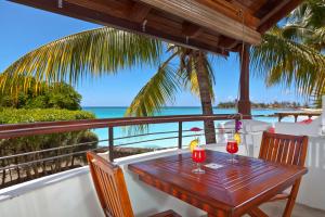 einen Tisch auf einem Balkon mit Meerblick in der Unterkunft Le Beachclub in Pereybere