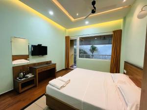 una camera con un grande letto e una televisione di EDENS SNOW CASTLE a Anachal