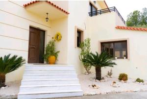 a house with stairs and plants in front of it at Villa Nostra Airport Pick-Up Service in Soroni