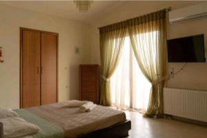 - une chambre avec un lit et une grande fenêtre dans l'établissement Villa Nostra- Cars Included, à Soroni