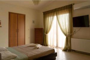 a bedroom with a bed and a large window at Villa Nostra Airport Pick-Up Service in Soroni +42 photos