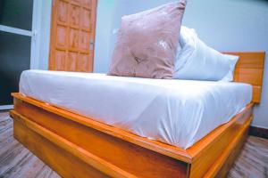 un letto con un cuscino sopra di Hadeb Property a Bukoba