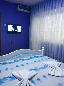 ein blaues Schlafzimmer mit einem Bett mit zwei Seestern in der Unterkunft Motel Albatros in Kosovo Polje