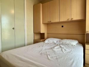een slaapkamer met een bed met witte lakens en kasten bij Appartement Argelès-sur-Mer, 2 pièces, 4 personnes - FR-1-225-101 in Argelès-sur-Mer