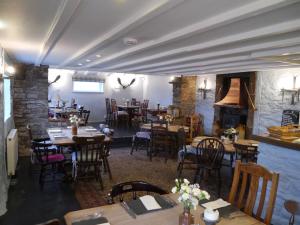 a restaurant with tables and chairs and a fireplace at The Garway Moon Inn in Garway