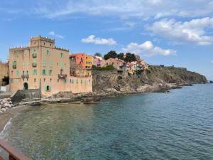 a building on a hill next to a body of water at 4SOM23 Appartement proche centre-ville in Collioure