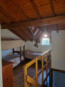 サンベルナルドにあるAltos SB Complejo Duplex 1の二段ベッド2組、木製の天井が備わる客室です。