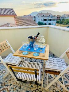 einen Tisch und Stühle auf einem Balkon mit einer Flasche Wein in der Unterkunft Casa Vittorina in Pula