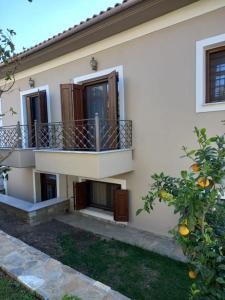 a white house with a balcony and an orange tree at The Villea Cottage - 5 bed house in Alli Meria in Álli Meriá