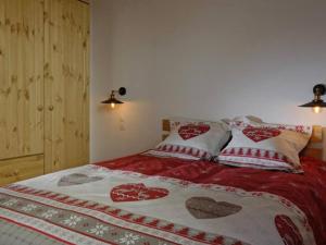 - un lit avec des couvertures et des oreillers rouges et blancs dans l'établissement Maison Villard-de-Lans, 5 pièces, 10 personnes - FR-1-548-38, à Villard-de-Lans