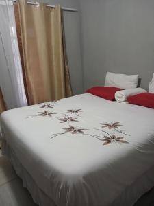 Un dormitorio con una cama blanca con flores. en Partulaka Rest Inn, en Maun