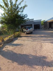 a car parked in a driveway next to a building at Partulaka Rest Inn in Maun