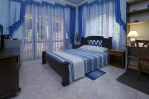 SeyBreeze Villa في آنس رويال: غرفة نوم بسرير والجدران الزرقاء والستائر