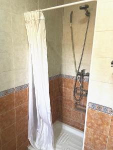 y baño con ducha con cortina blanca. en Villa Rubio Vega, en Chiclana de la Frontera