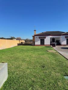 un edificio con un patio de césped delante de él en Villa Rubio Vega, en Chiclana de la Frontera