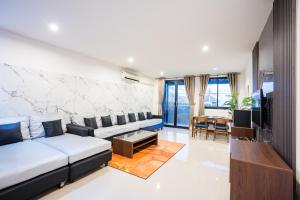 ein Wohnzimmer mit einem Sofa und einem TV in der Unterkunft Anda Sea View Pranburi in Ban Pak Nam Pran