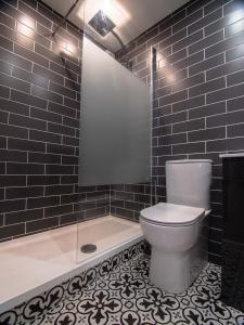 a bathroom with a toilet and a shower and a tub at City Walk Apts in Dublin