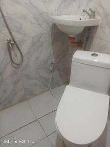 La salle de bains est pourvue de toilettes blanches et d'un lavabo. dans l'établissement Akoya Beach Park and Cottages, à Locaroc