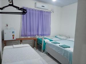 a hospital room with two beds and a table at Chacara Cabana dos Lagos in Riachão