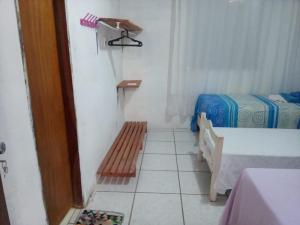 Cette petite chambre comprend deux lits et un banc. dans l'établissement Chacara Cabana dos Lagos, à Riachão