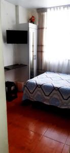 1 dormitorio con cama y ventana grande en Acojedor, en Lima