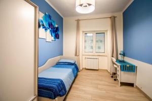 1 dormitorio con paredes azules, 1 cama y escritorio en Color House en Nápoles
