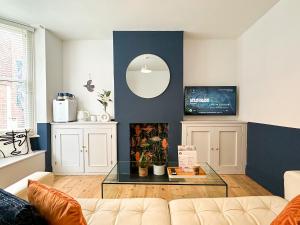 a living room with a couch and a mirror at Love Lane - Cosy & Modern City Centre Guest Suite in Canterbury