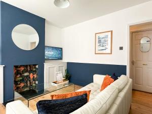 een woonkamer met een witte bank en een spiegel bij Love Lane - Cosy & Modern City Centre Guest Suite in Canterbury