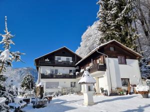 una casa en la nieve con una casa de pájaros en Ferienhaus Burgblick, en Treffen