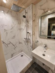 a bathroom with a sink and a shower and a tub at Golden GaPa "Gasthof zum Lamm" in Garmisch-Partenkirchen