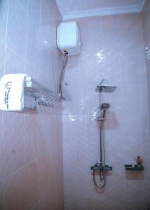 - Baño con ducha y toalla en la pared en Hadeb Property, en Bukoba