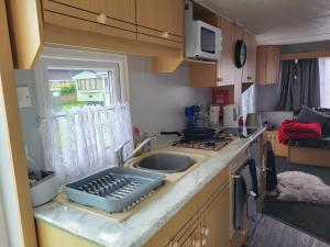 a kitchen with a sink and a counter top at Chapel's cozy caravan in Chapel Saint Leonards