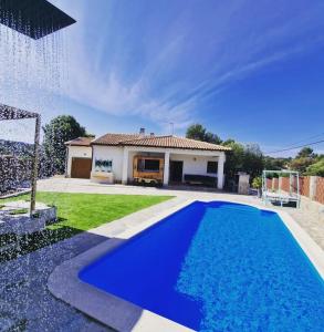 una piscina azul frente a una casa en Casa Rural Zahoko, en Guadalajara