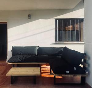 a black couch sitting in a room with a window at Casa Rural Zahoko in Guadalajara