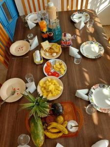 uma mesa de madeira coberta com pratos e tigelas de comida em A Lovely smart family guest house em Kisii