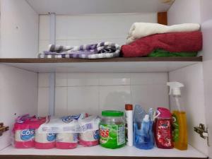 a shelf with toothbrushes and cleaning products in a bathroom at A Lovely smart family guest house in Kisii