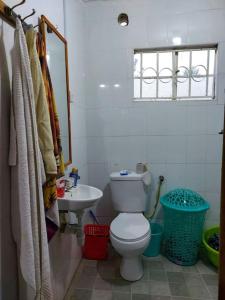 a bathroom with a white toilet and a sink at A Lovely smart family guest house in Kisii